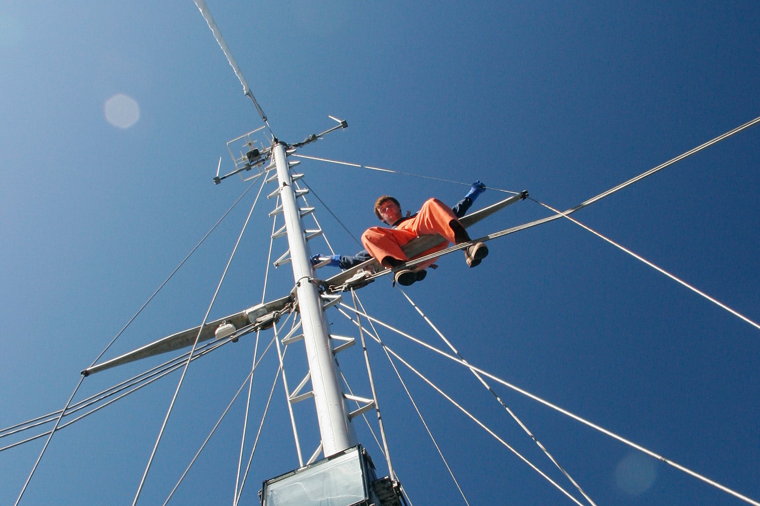 Man sitting on the mast of a fishing boat